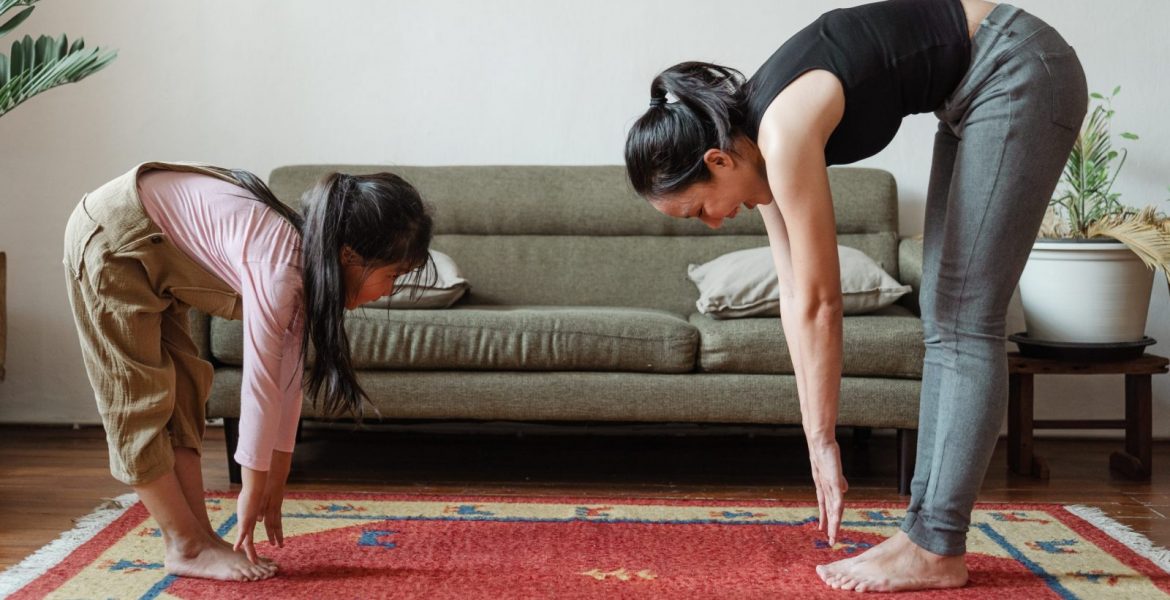 happy-barefoot-asian-woman-and-adorable-daughter-stretching-4473636